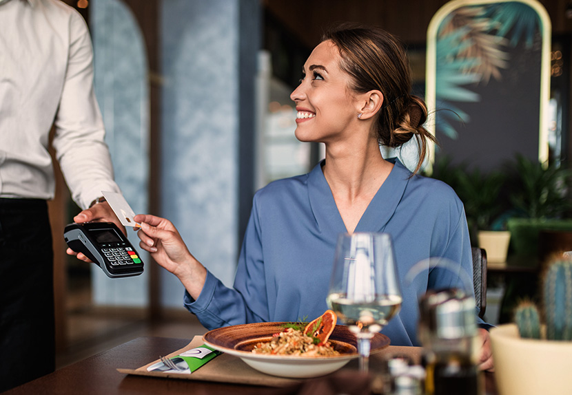Landmark member using the contactless feature on their debit card to pay for meal and earn rewards.