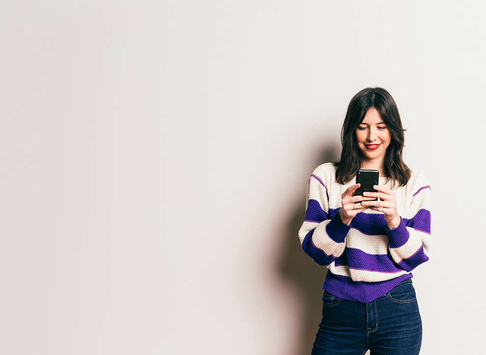 A woman on her phone smiling
