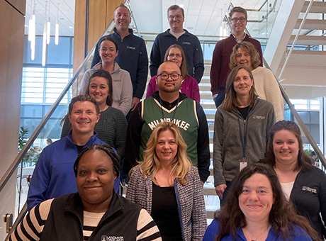 A group picture of several Landmark associates is taken on the corporate office staircase.