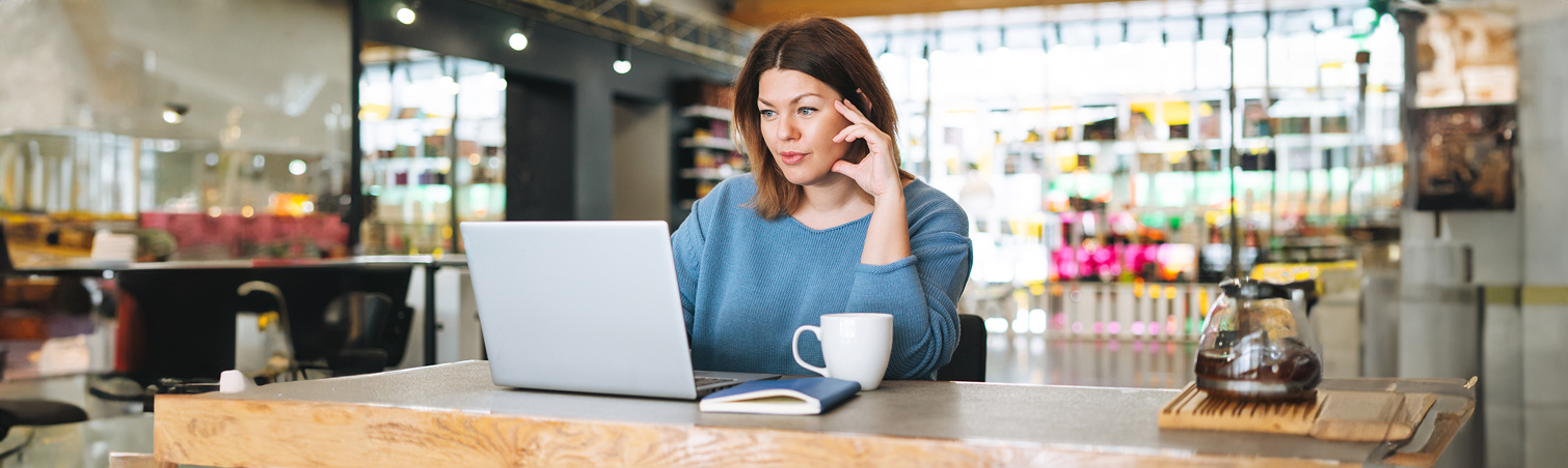 A member is on their laptop reading about techniques for increasing their daily, weekly, and monthly savings.