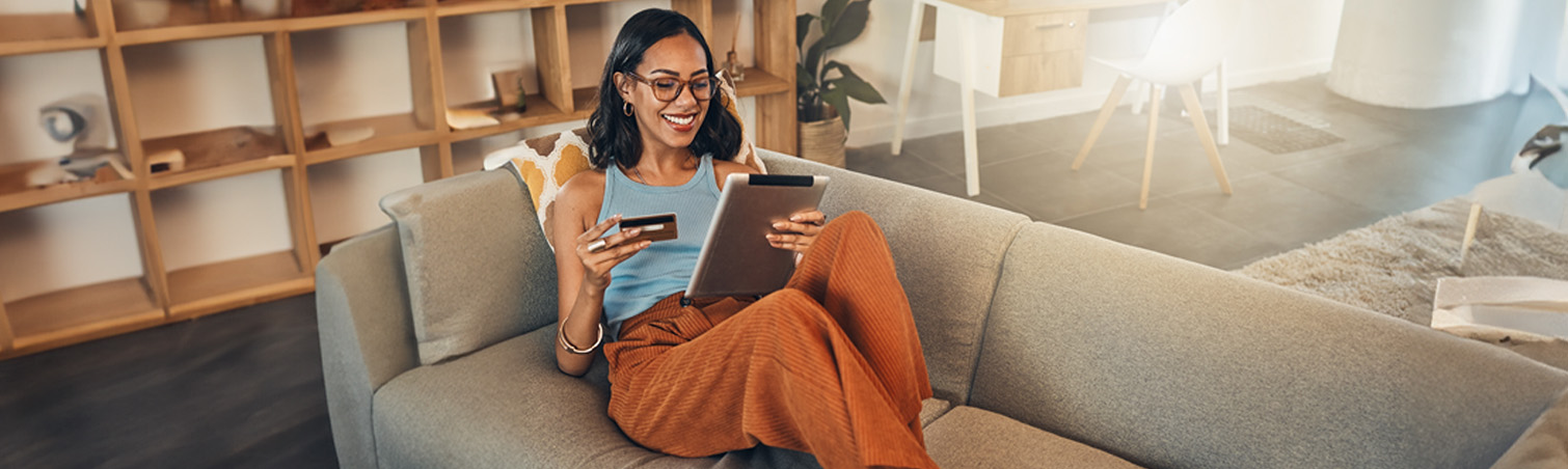 A member is smiling on their couch as they learn about the benefits of Credit Hub. 