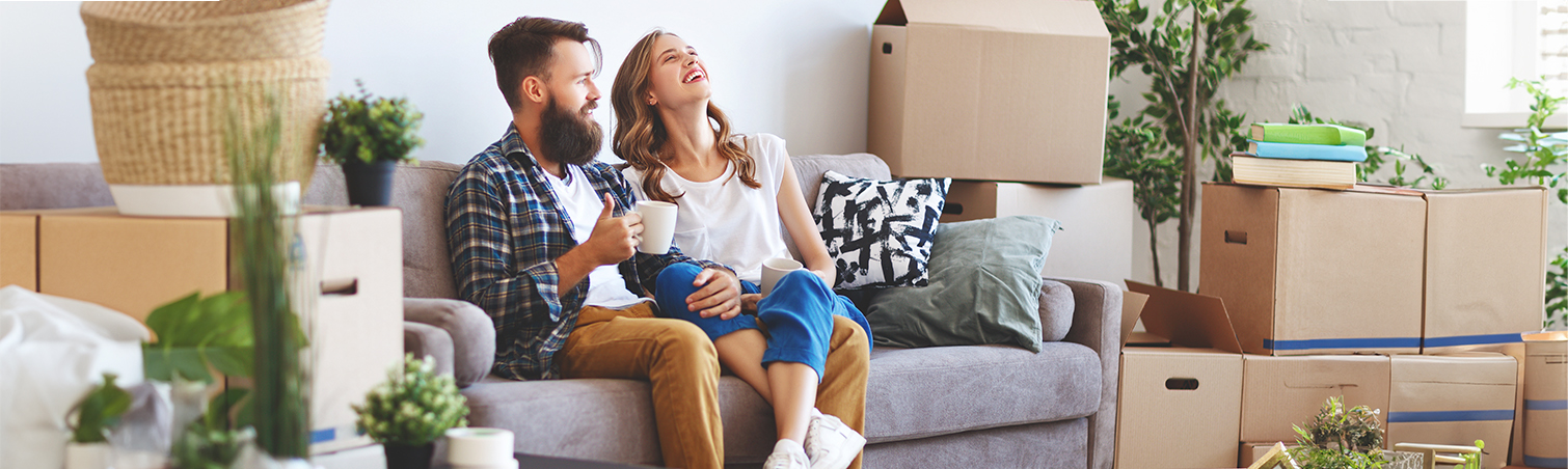 A young couple who have recently moved into their new home are relishing their time together on the couch.